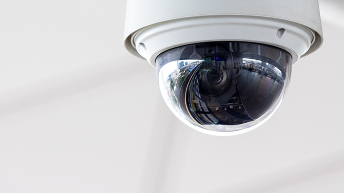 A dome shaped ceiling mounted surveillance camera.