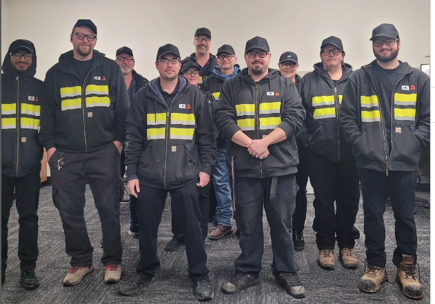 A group of technicians pose for the camera.