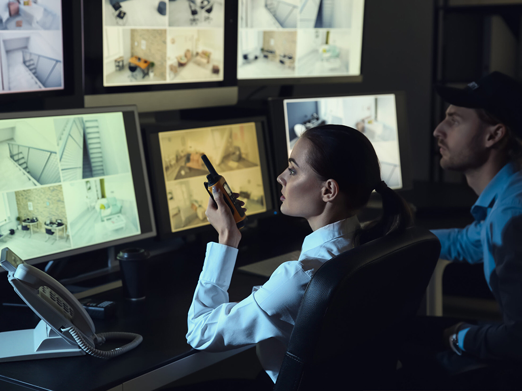 Inside a surveillance room with many tv screens.