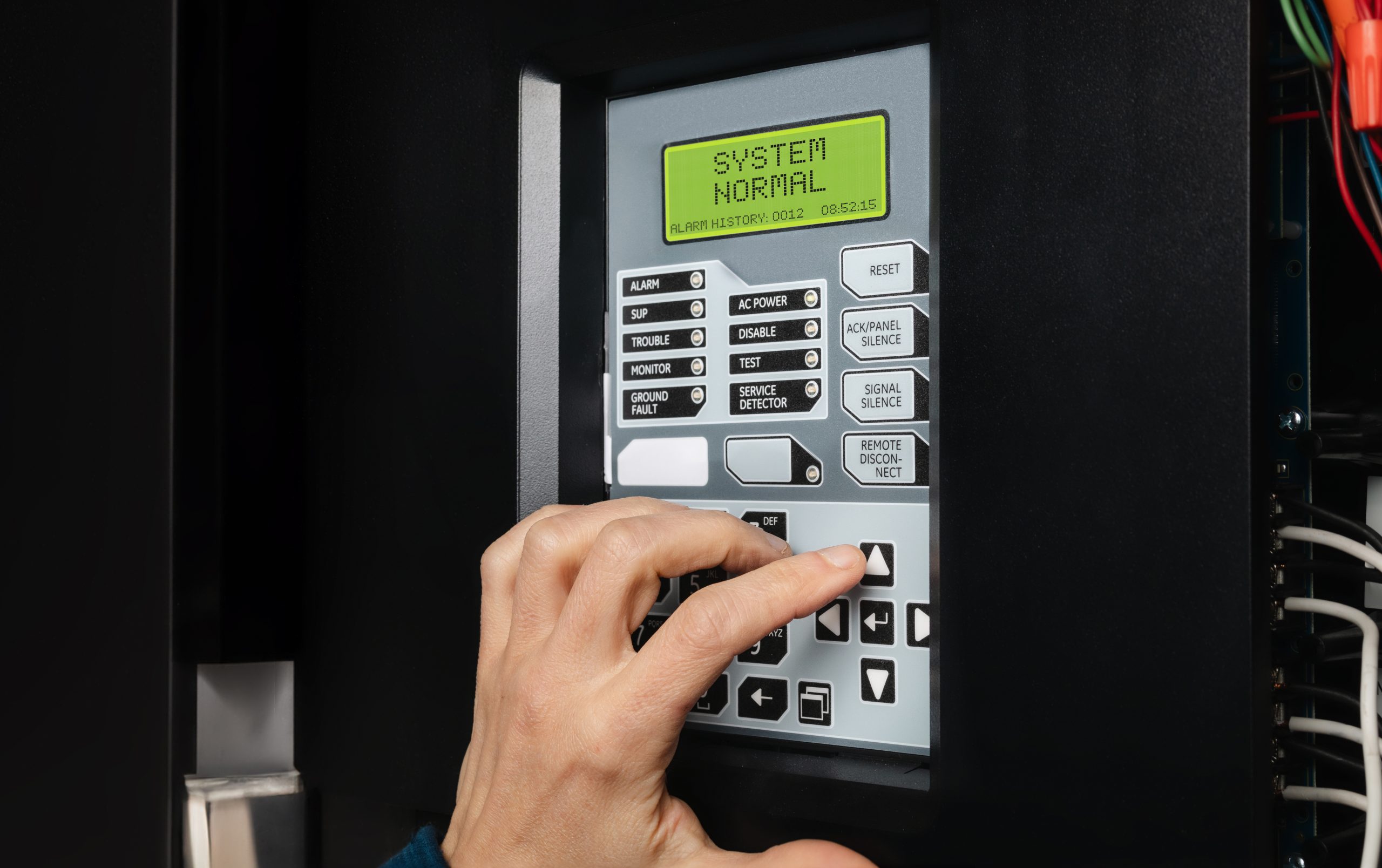 A close up of fingers pressing buttons on a system panel.